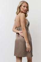 Woman wearing a brown nightdress against a white background