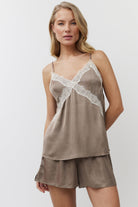 Woman wearing a brown lace-trimmed nightgown with shorts on a white background