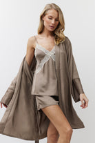 Woman wearing a brown satin nightgown and pajama set on a white background