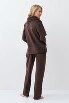 Person wearing a brown outfit on a white background