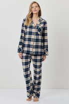 Woman wearing a blue and beige plaid pajama set on a white background