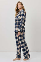 Woman wearing a blue and beige plaid pajama set against a white background
