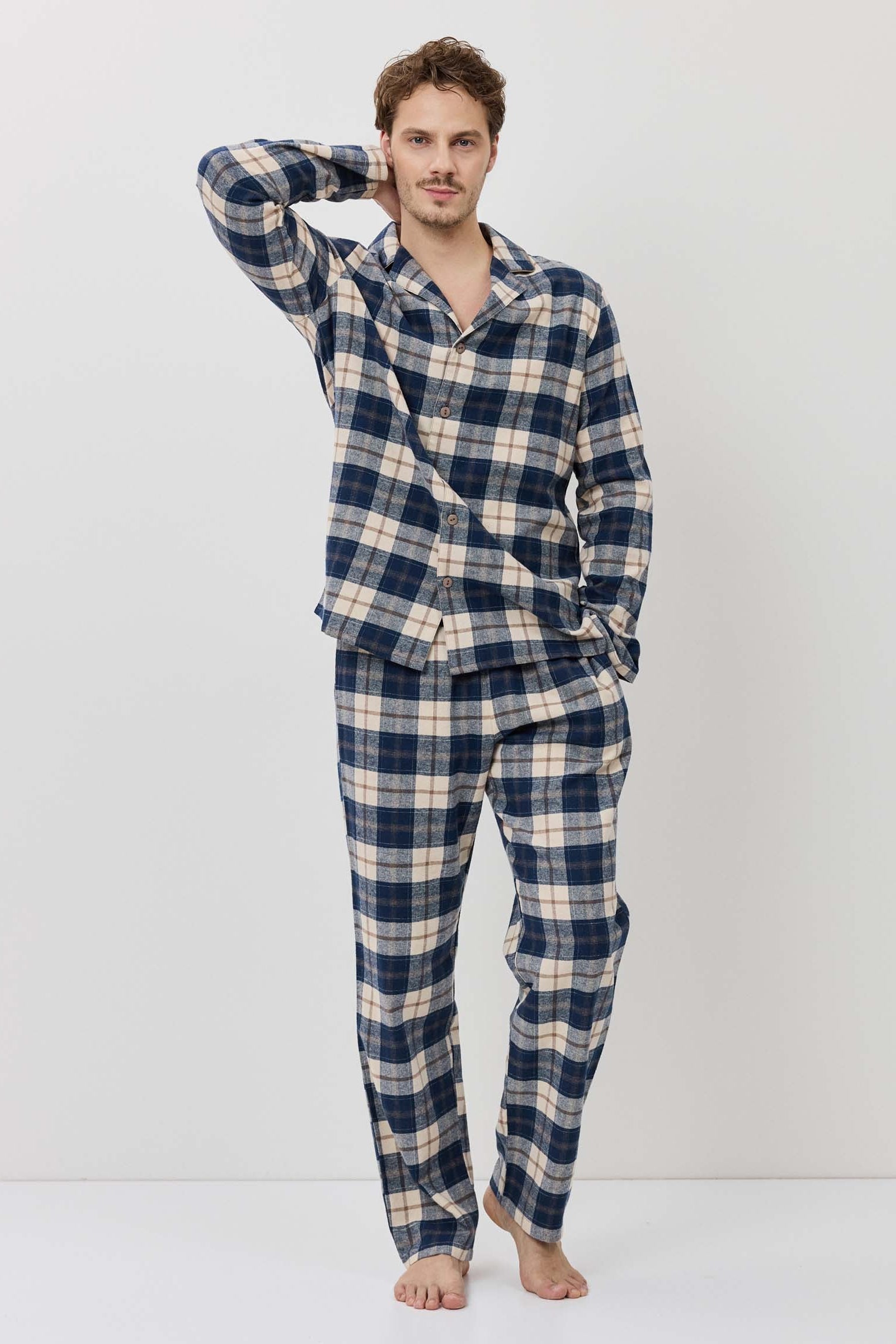 Man wearing a blue and white checkered pajama set on a white background