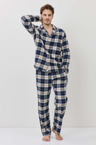 Man wearing a blue and white checkered pajama set on a white background