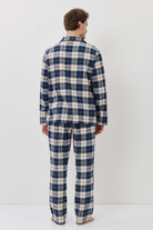 Person wearing a blue and white plaid pajama set against a white background