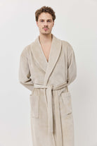 Man wearing a beige robe against a white background