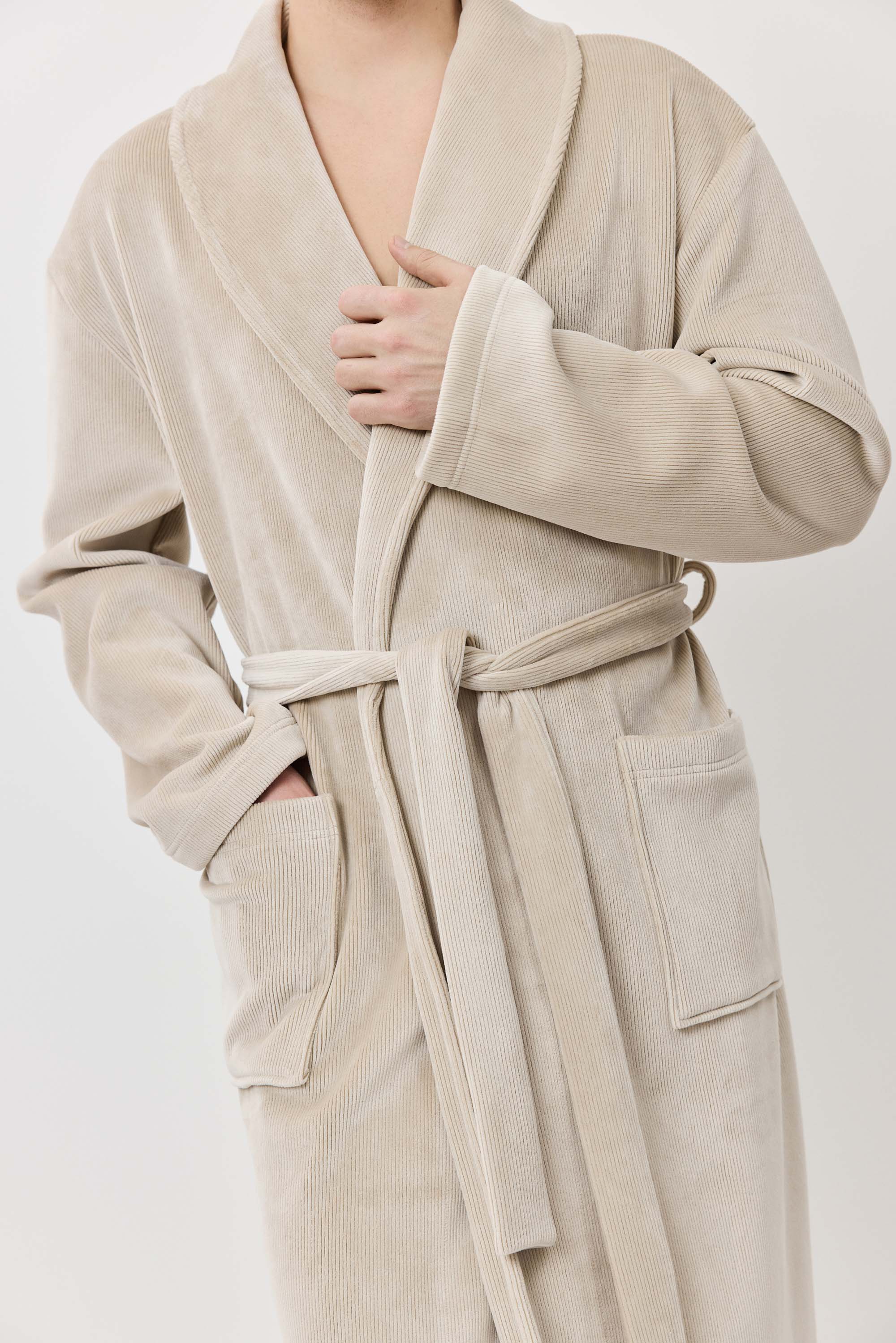 Beige robe worn by a person on a white background