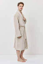 Man wearing a beige robe against a white background