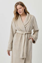 Woman wearing a beige robe against a white background