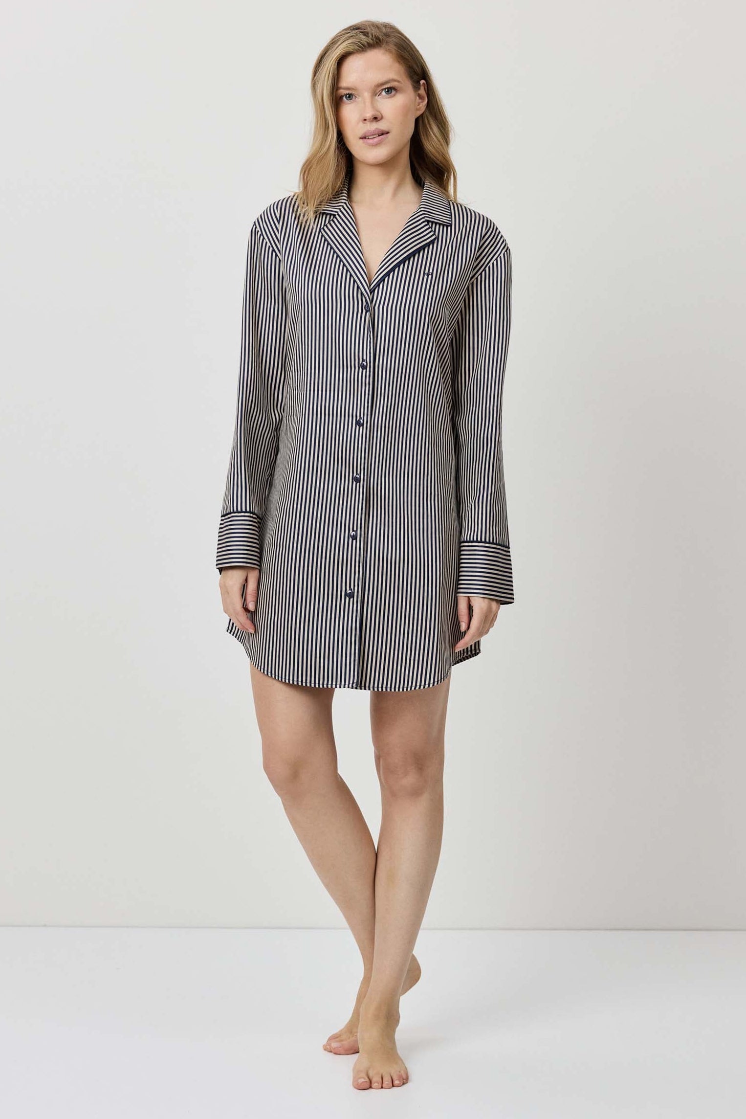 Woman wearing a gray checkered shirt dress on a white background