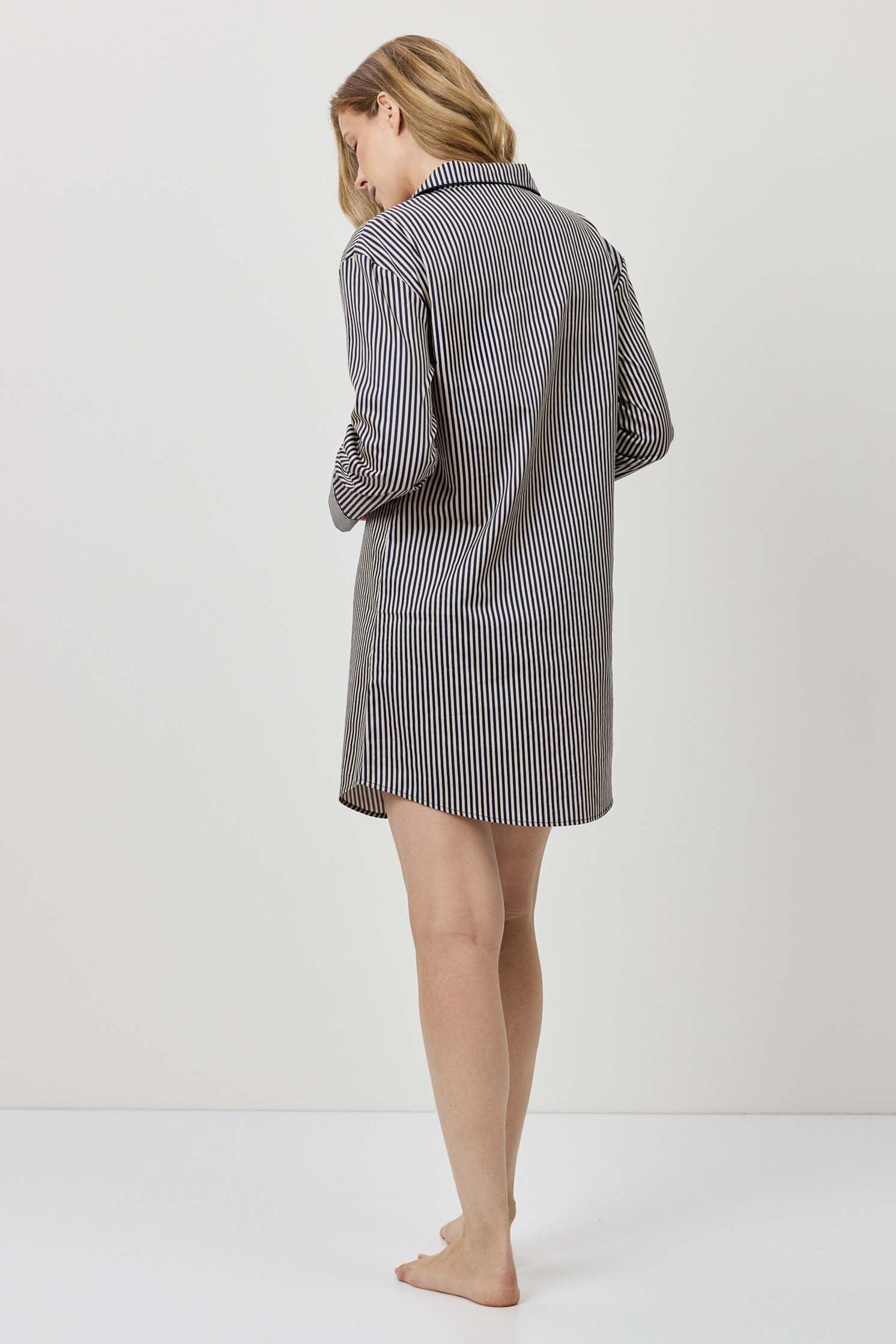Woman wearing a gray checkered dress against a white background