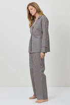 Woman wearing a gray striped pajama set on a white background