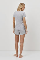 Woman wearing a gray pajama set on a white background