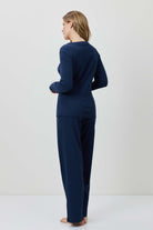 Person wearing a navy blue outfit standing against a white background