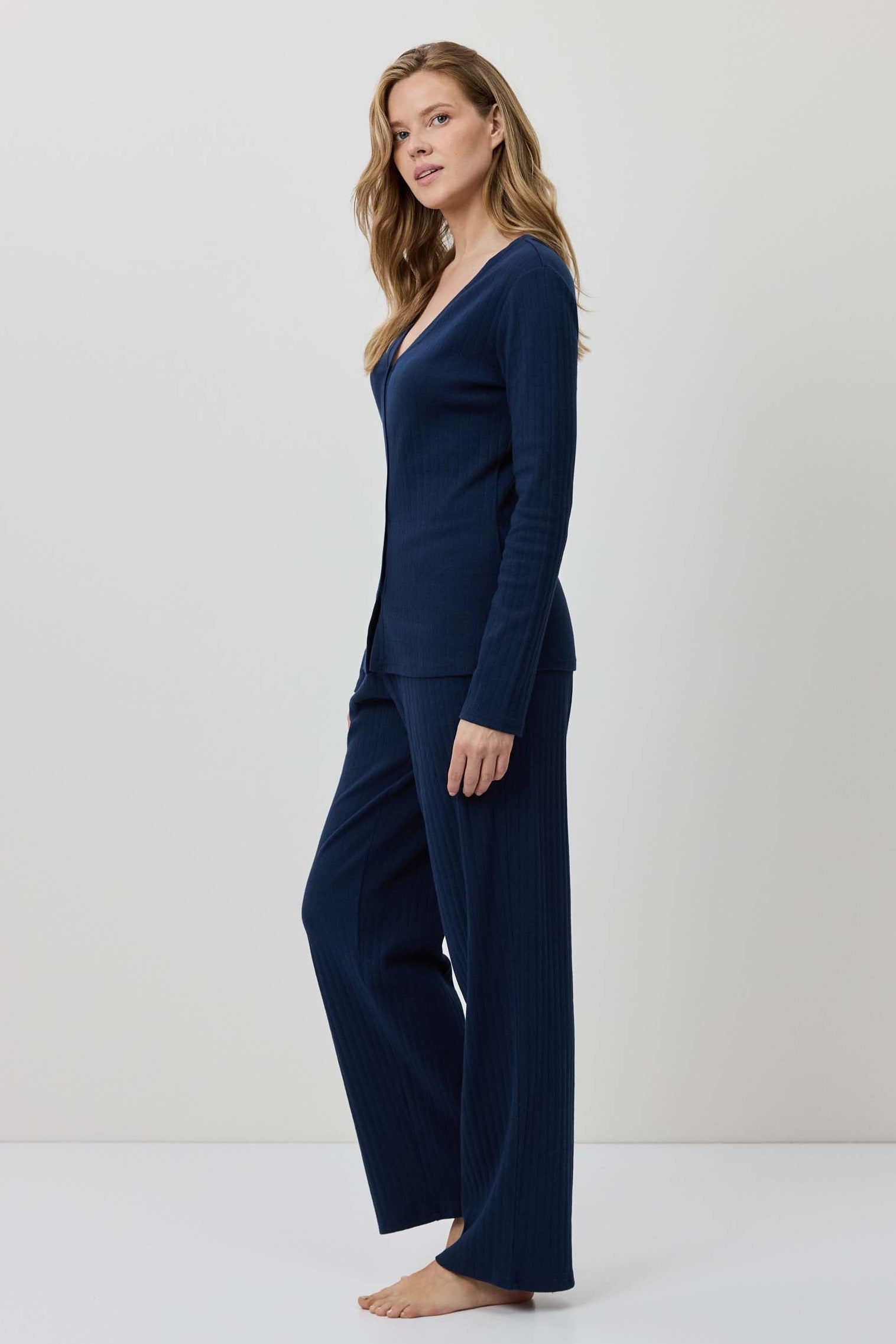 Woman wearing a navy blue outfit against a white background