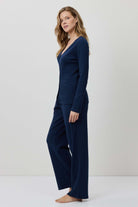 Woman wearing a navy blue outfit against a white background
