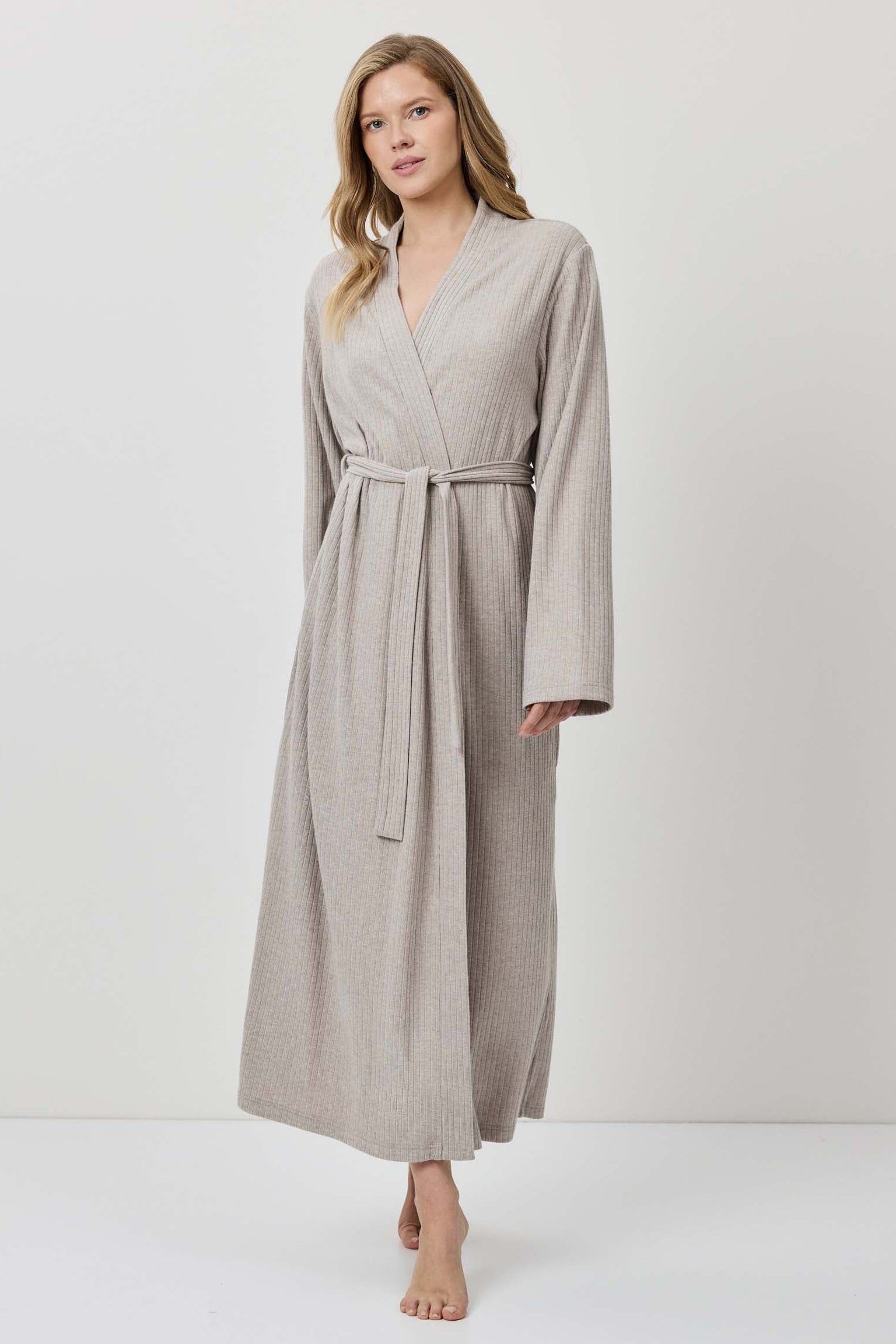 Woman wearing a beige robe against a white background