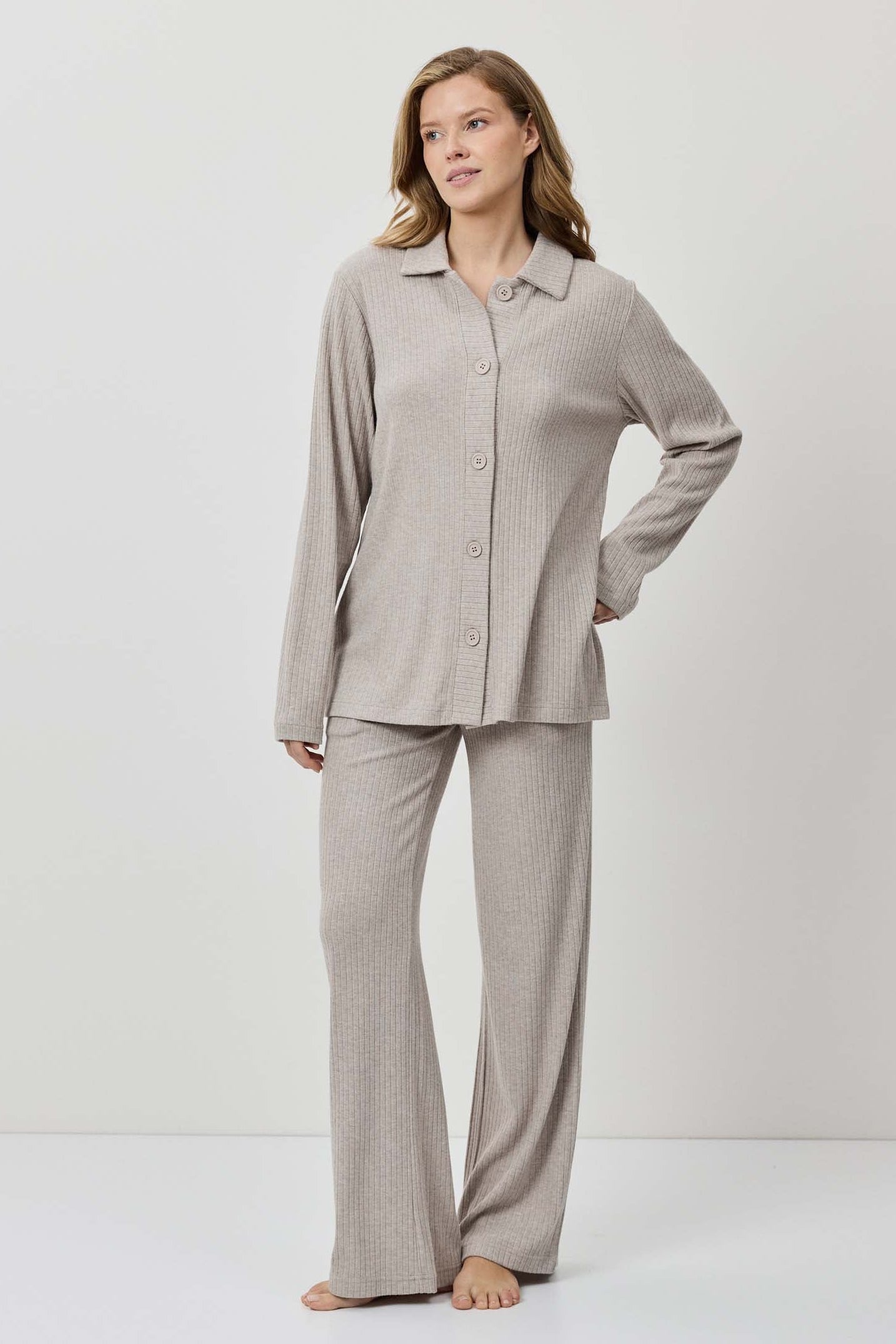 Woman wearing a gray pajama set on a white background