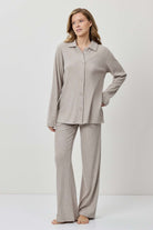 Woman wearing a gray pajama set on a white background