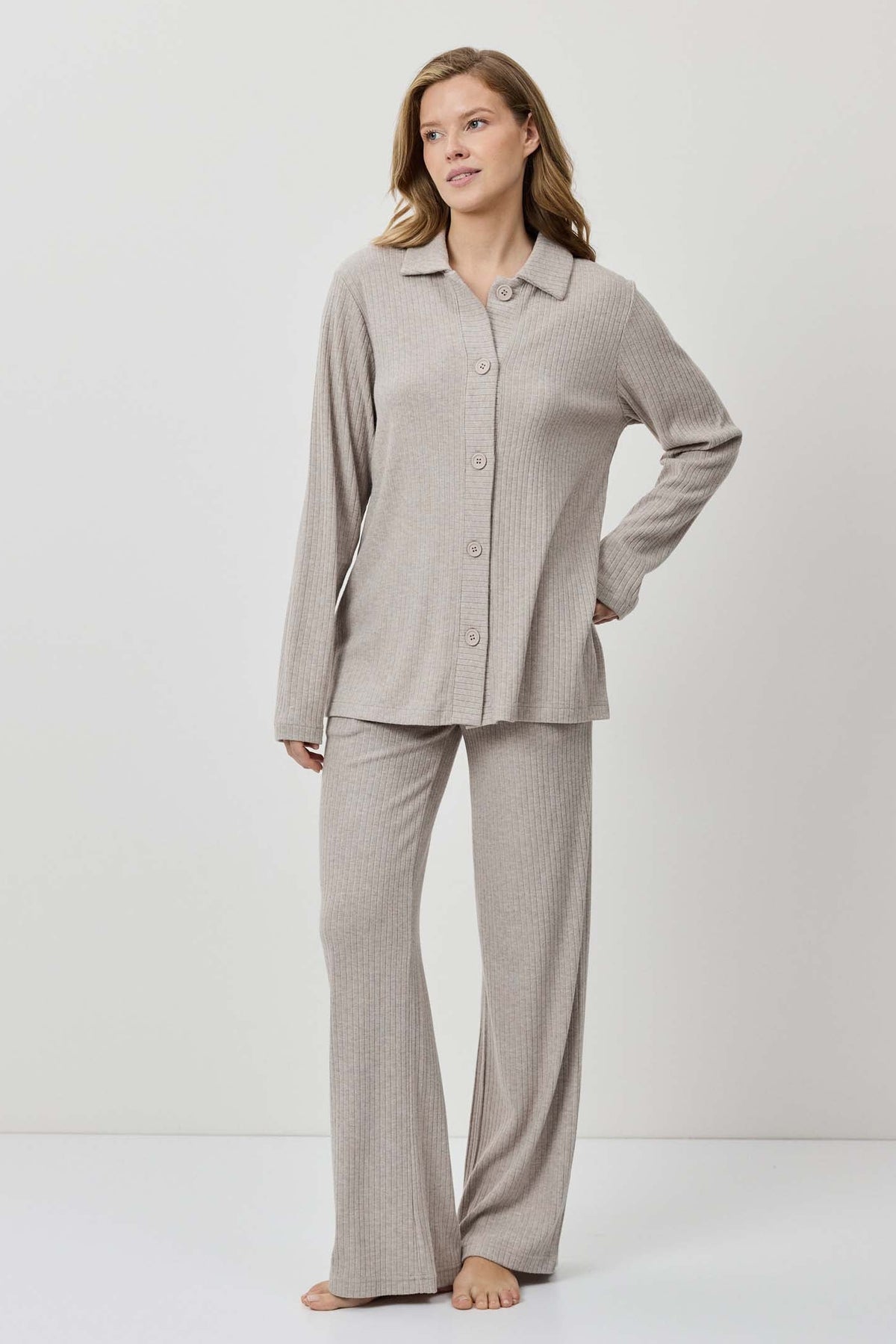 Woman wearing a gray pajama set on a white background