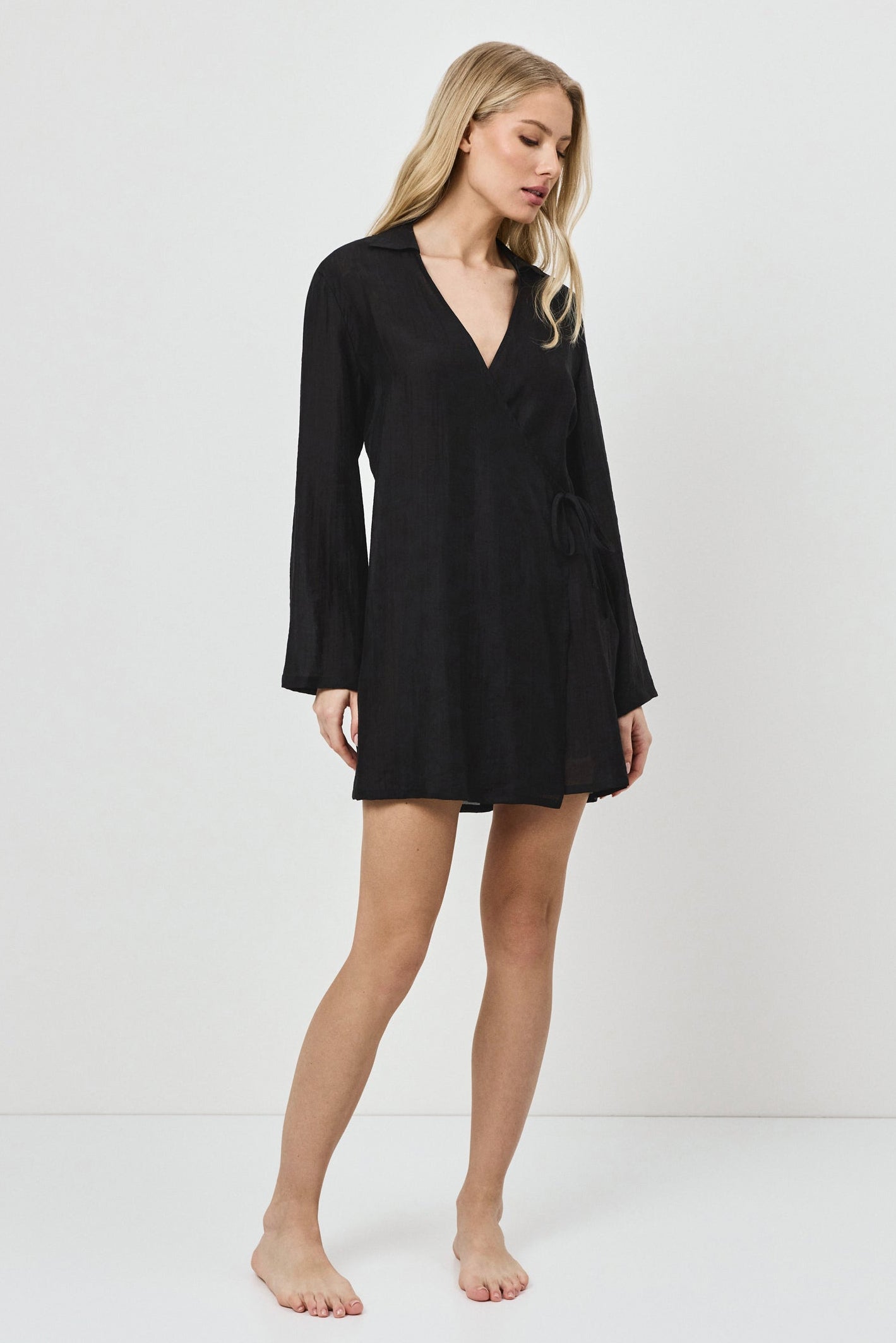 Woman wearing a black long-sleeve dress on a white background