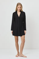 Woman wearing a black dress against a white background