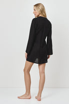Woman wearing a black dress against a white background