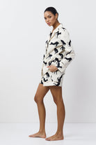 Woman wearing a black and white patterned pajama set on a white background