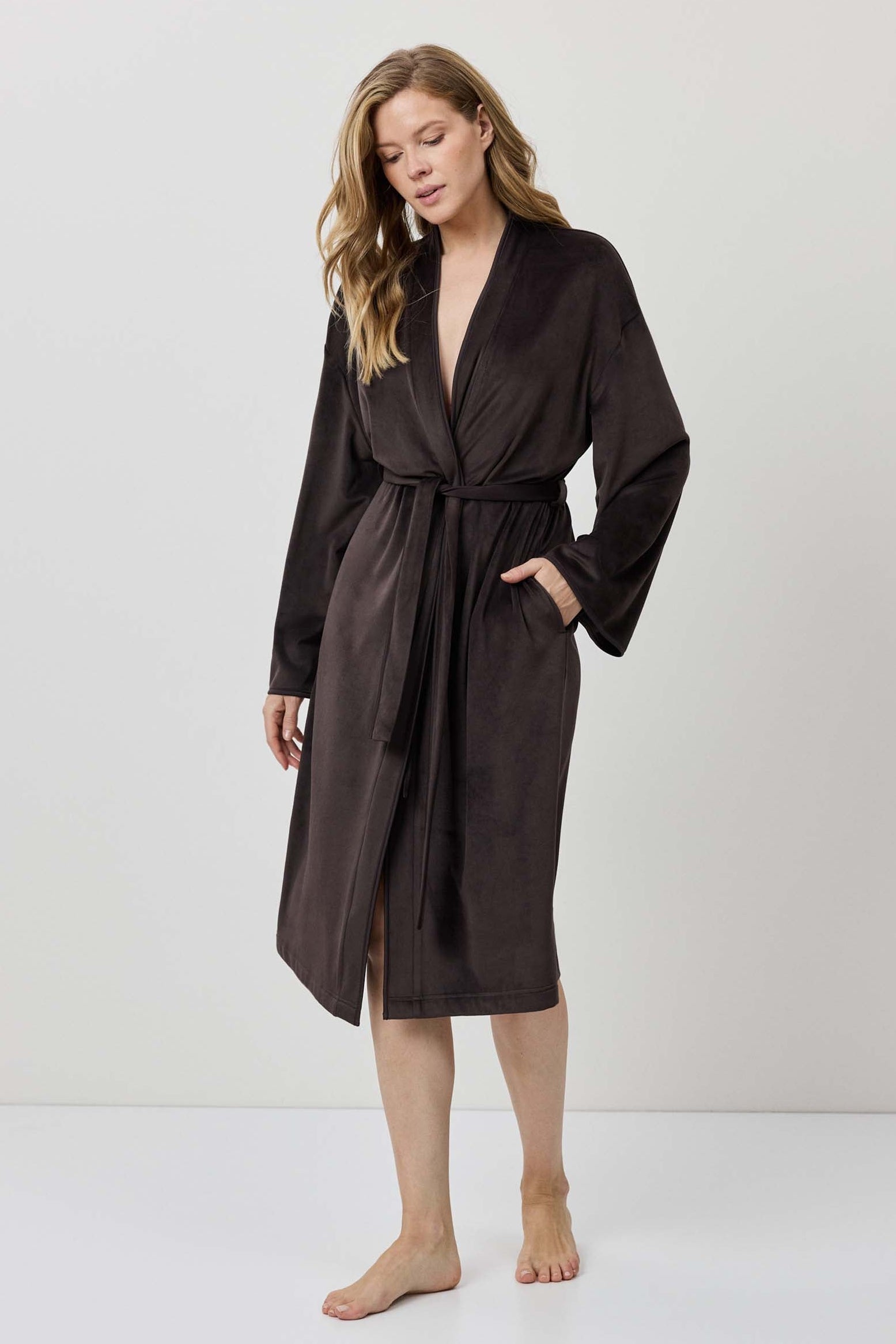 Woman wearing a brown robe against a white background