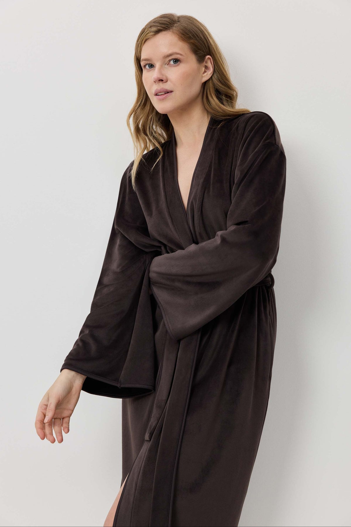 Woman wearing a dark brown robe against a white background