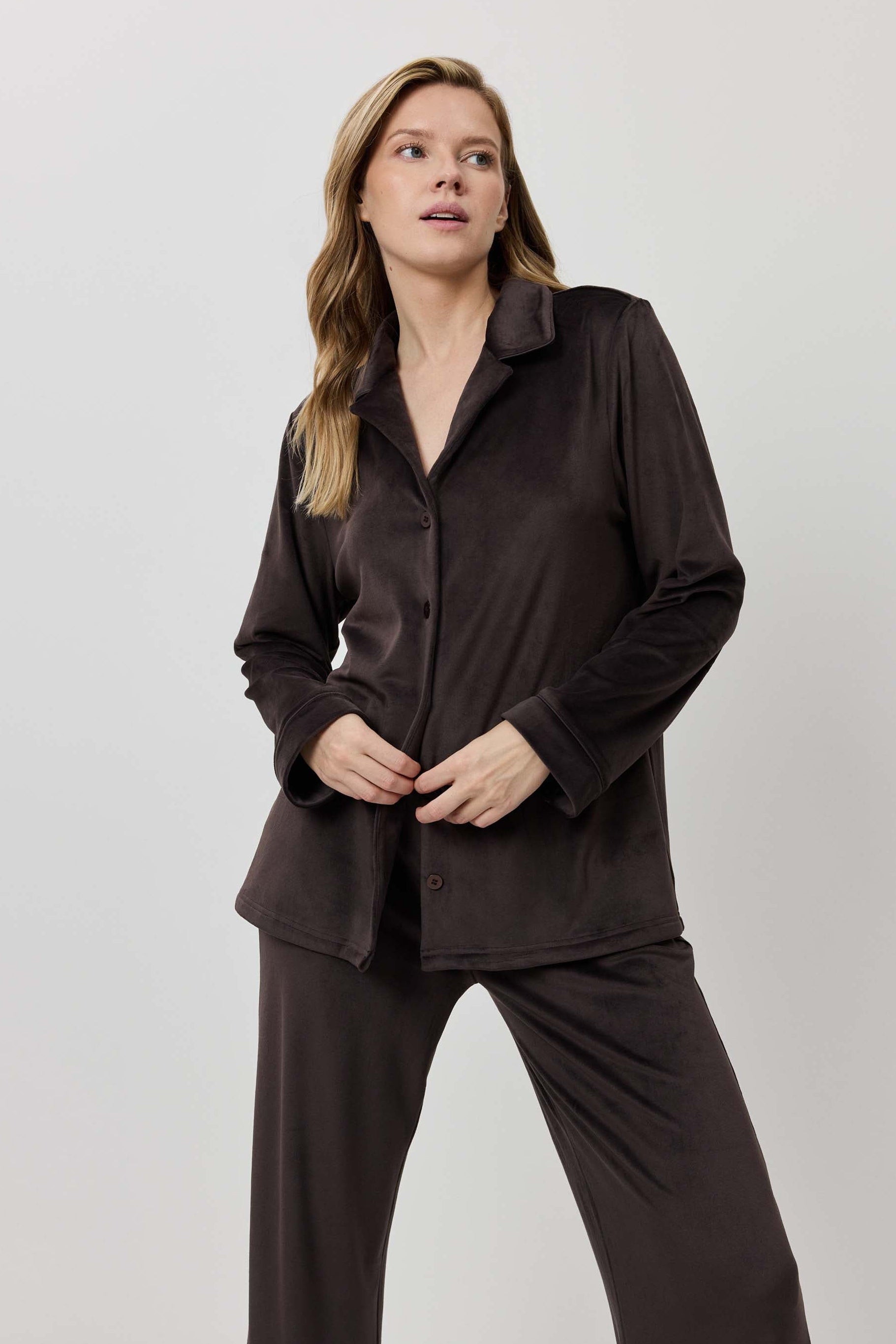 Woman wearing a brown outfit against a white background