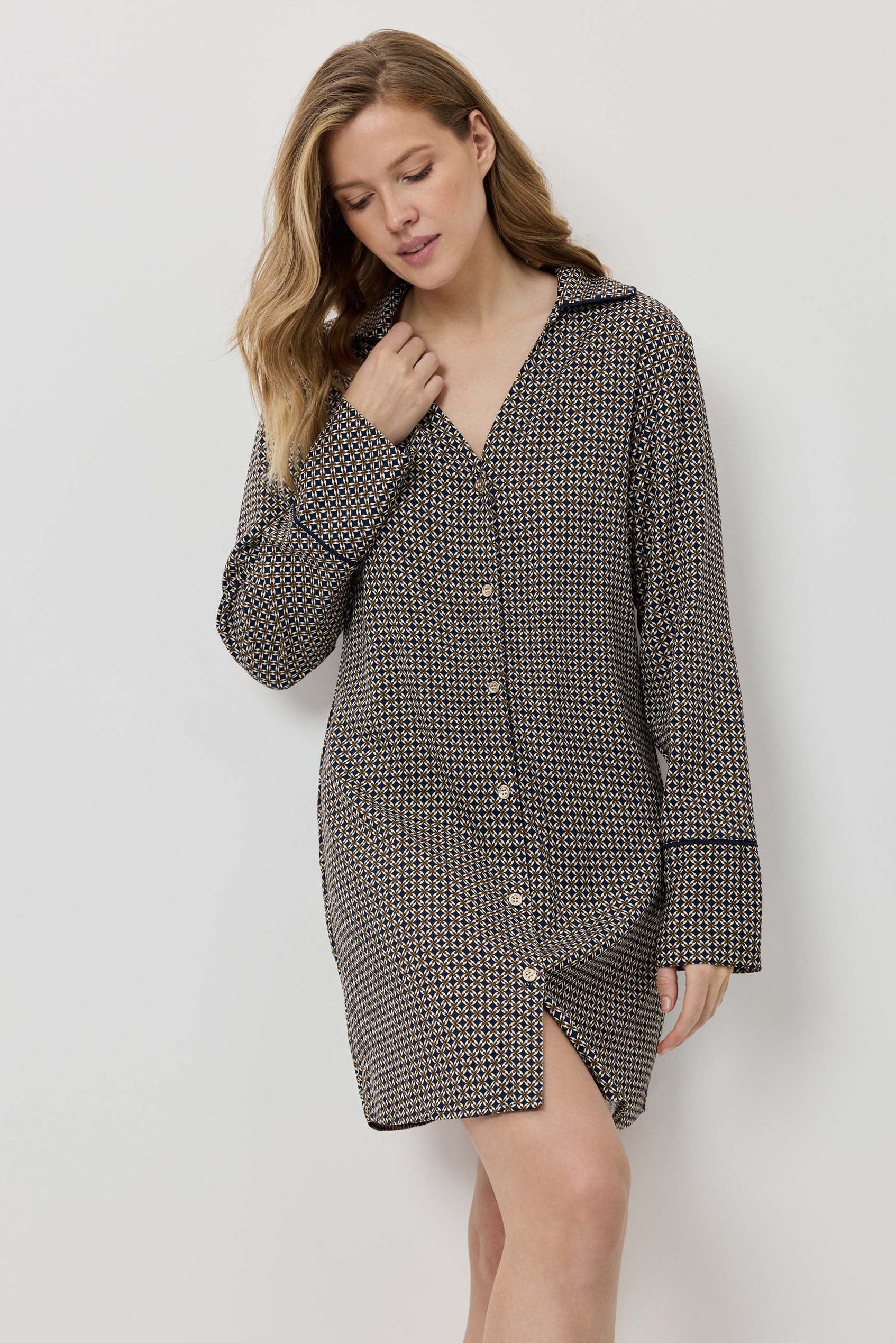 Woman wearing a houndstooth patterned dress against a white background