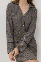 Woman wearing a houndstooth patterned outfit against a plain background
