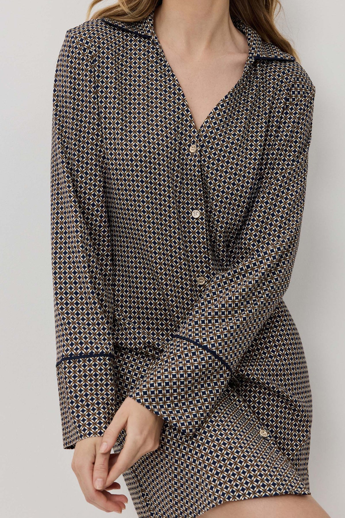Woman wearing a houndstooth patterned outfit against a plain background