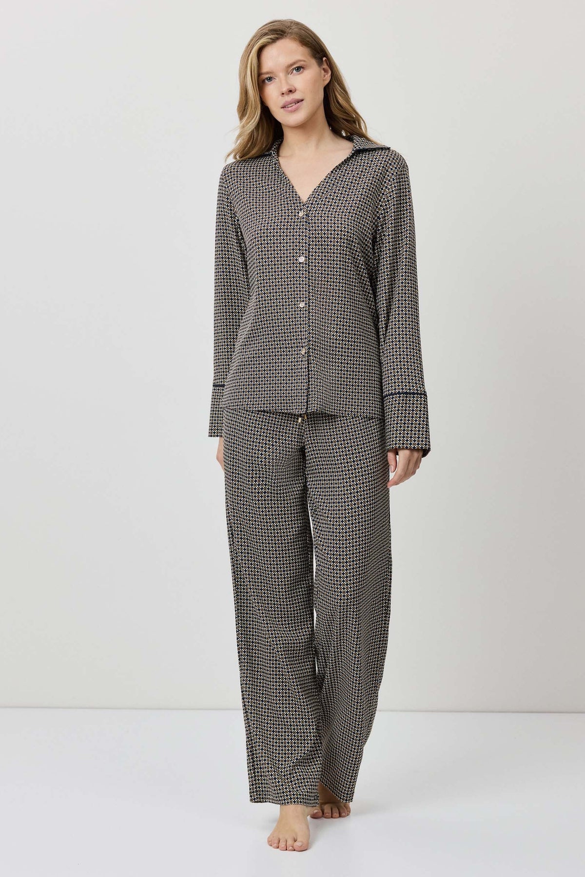 Woman wearing a gray checkered pajama set on a white background