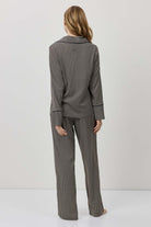Person wearing a gray checkered outfit on a white background