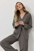 Woman wearing a houndstooth patterned suit against a plain background