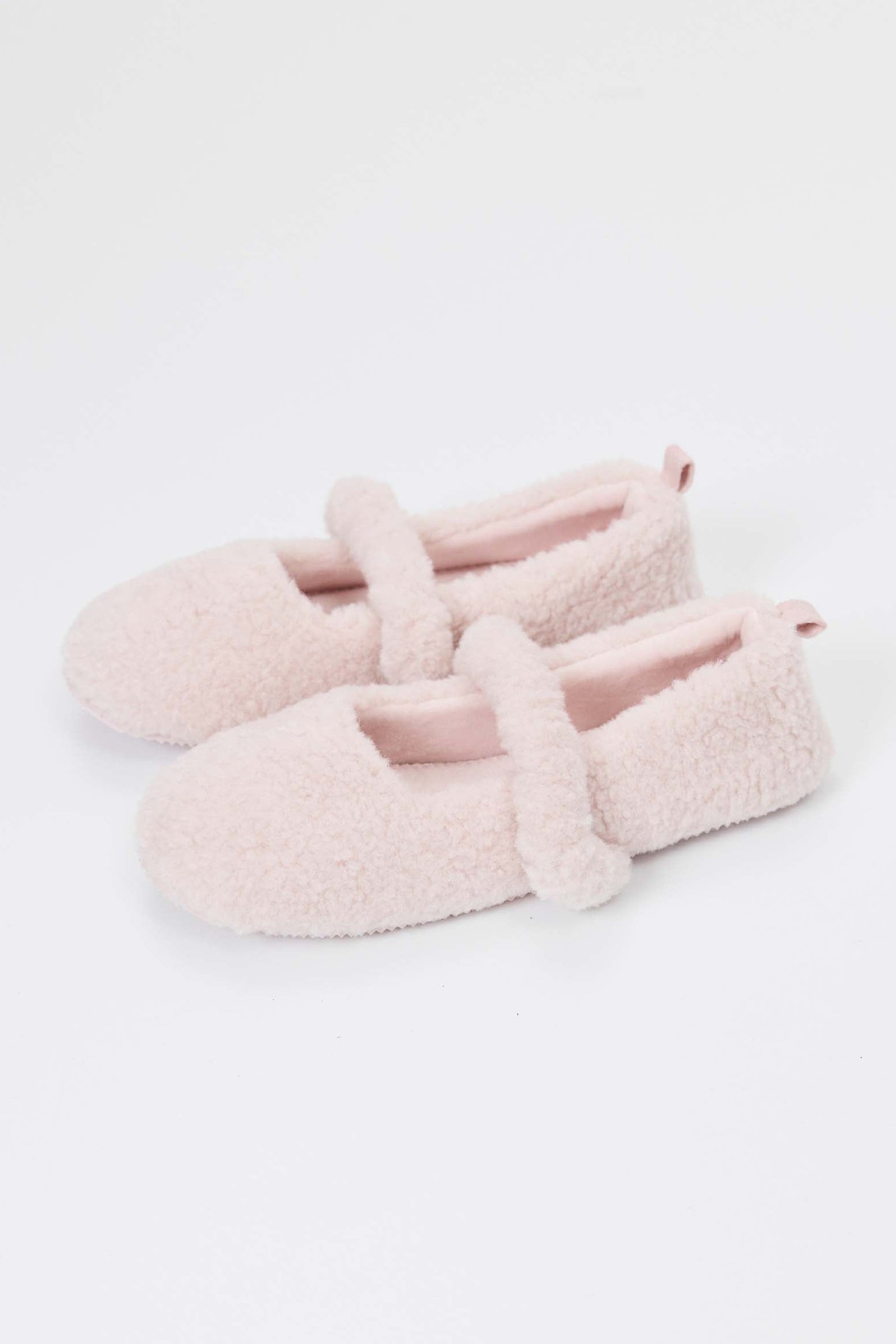 Pair of pink fuzzy slippers on a white background