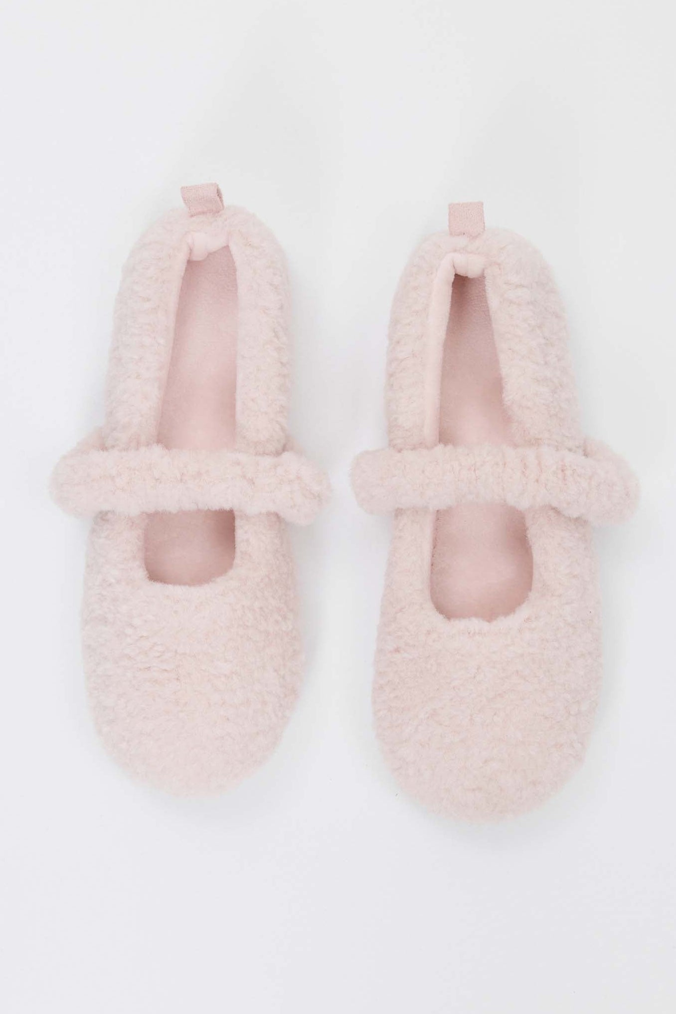 Pair of pink fuzzy slippers on a white background