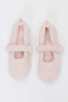 Pair of pink fuzzy slippers on a white background