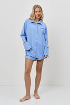 Woman wearing a blue pajama set on a white background