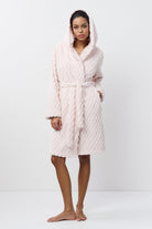 Person wearing a textured pink bathrobe on a white background