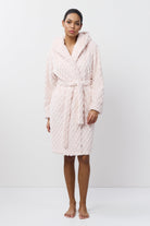 Person wearing a pink quilted bathrobe on a white background