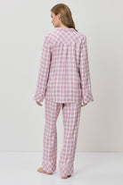 Person wearing pink checkered pajamas on a white background