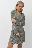 Woman wearing a checkered nightdress against a white background