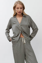 Woman wearing a patterned pajama set on a white background