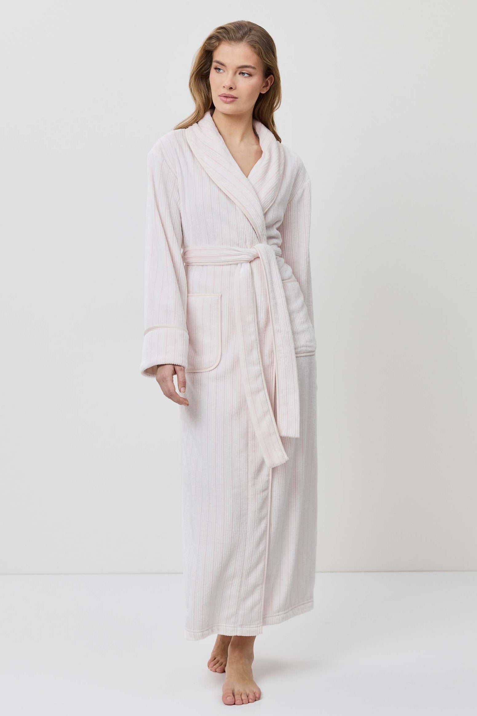 Woman wearing a beige robe on a white background
