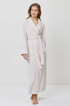 Woman wearing a beige robe on a white background