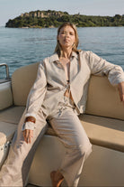 Woman sitting on a boat with a scenic background of water and land.