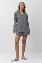 Woman wearing a black and white striped pajama set on a white background